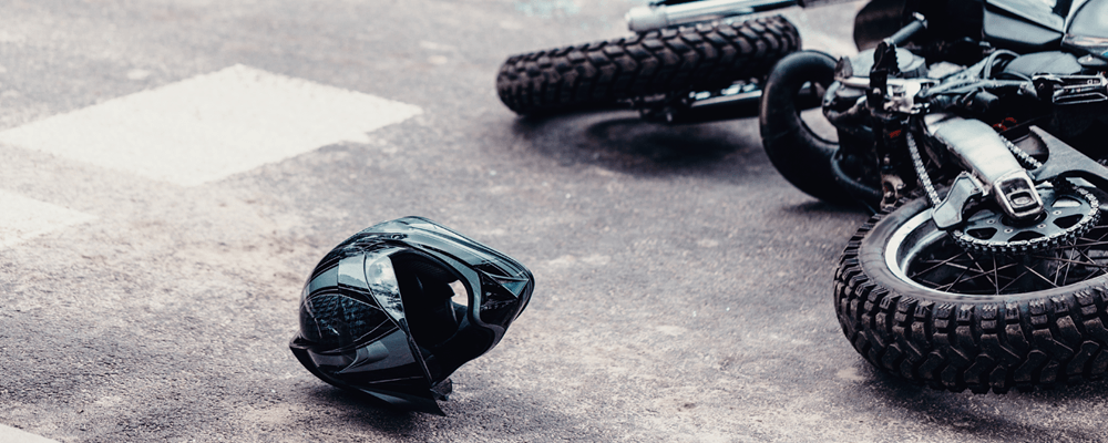 a motorcycle is laying on its side in the road along with a black helmet