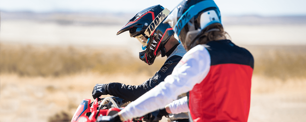 Two people in the desert riding dirtbikes