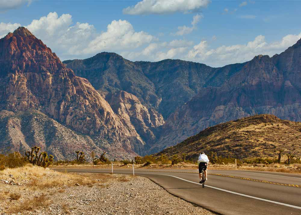 Male riding on a paved highway through the mountains