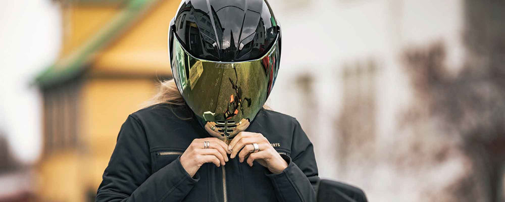 Woman donning a helmet with a reflective face shield