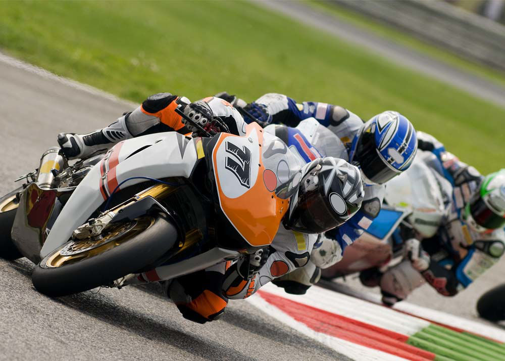 Mid-turn shot of 3+ motorcyclists racing on a race track