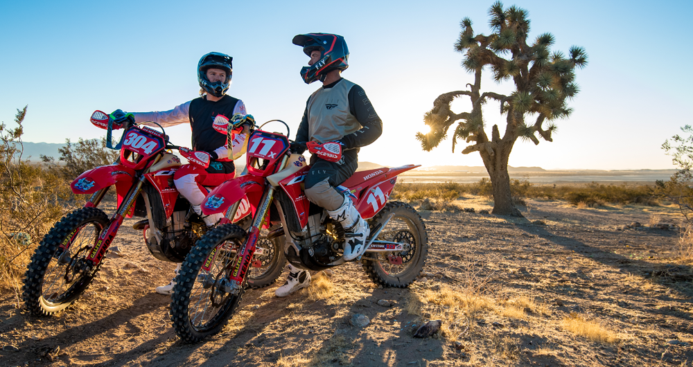 Two young adult males on Red Honda dirt bikes in the Southwest at sunset.