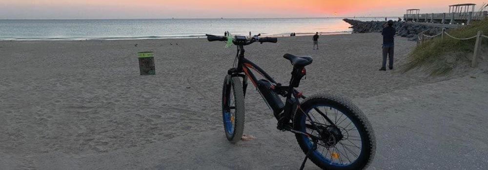 An Ecotric Rocket eBike parked on a beach.