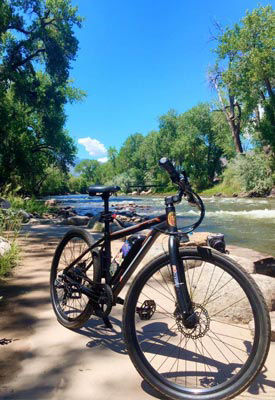 An Ecotric Vortex eBike parked on the bank of a river.